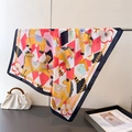 Close-up of silk-feel square scarf featuring carousel horse print and gold chain patterns - Warm Orange