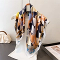 Elegant silk scarf with horse and chain print, draped on hanger for a stylish look - Black Orange