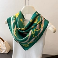 Élégant foulard en soie vert émeraude avec motif chaîne dorée exposé sur un cintre - Vert