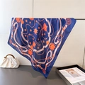 Gros plan d'un foulard en soie bleu marine avec chaînes orange sur une tige en métal - Bleu marine