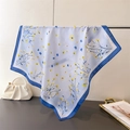 Detail of light blue floral silk scarf draped on a metal bar in a lifestyle setting - 66-70CM / Blue Trim