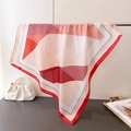 Dettaglio di un foulard in seta geometrico con bordi rossi drappeggiato su supporto - Bordo Rosso