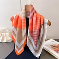 Foulard di seta moderno con righe geometriche arancio e rosa appeso a una gruccia - Bordo Arancione