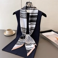 Seidenschal mit geometrischem Muster und Kamelien-Brosche auf dunkelblauer Weste - Schwarz Weiß Rosa Blau Geometrisches Patchwork (LE-306)