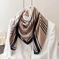 Dettaglio della trama di un foulard geometrico in seta drappeggiato su un blazer bianco - 90x90cm / Rosa nudo