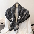 Detailed texture of camellia floral print silk scarf styled with a white blazer - Black