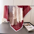 Deep red silk-like square scarf with elegant peony floral print draped over a metal stand - Red