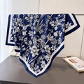 Elegant navy blue silk scarf with white floral sketch print hanging on a metal rack - Navy Blue