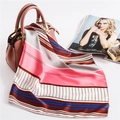 Detailed view of a colorful striped silk scarf elegantly draped over a pink handbag - 50cm x 50cm / Pink-Brown Stripes