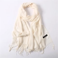 Detailed macro view of cream cashmere scarf with delicate tassel fringe and soft texture - Beige
