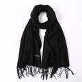 Detail shot of black cashmere scarf texture with soft fringe and sewn fabric label - Black