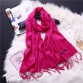 Detailed close-up of a magenta cashmere scarf with fringe and a sewn-on brand label - Rose Red (FYR150-04)