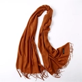 Detail of caramel cashmere scarf texture with elegant fringed ends on white background - Caramel