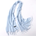 Detail of light blue cashmere scarf showing fine tassel fringe and material label - Light Blue