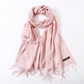 Close-up of pink cashmere scarf fringe detail and black sewn brand label on a soft fabric - Light Pink