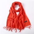 Detail shot of a bright orange cashmere scarf showing fine texture and fringe tassels - Orange Red