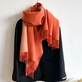 Detail view of double-sided orange and beige scarf with tassel edge on black coat - 200x65cm / Orange And Apricot (WT350-11)