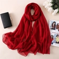 Dettaglio di sciarpa in chiffon rosso con trama traslucida e cuciture su uno sfondo beige - Rosso Vino