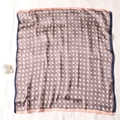 Detail of silk square scarf with horse head pattern and contrast border on white background - 70x70cm / Dark Camel