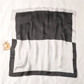Detail of elegant black and white silk square scarf with geometric pattern and glossy finish - Black and White