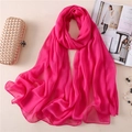 Dettaglio di una sciarpa in chiffon rosa fucsia con accessori in stile lifestyle - Rosa Rossa