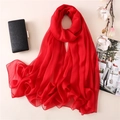 Dettaglio di una sciarpa in chiffon rosso a trama fine, drappeggiata con accessori moda - Rosso Cina