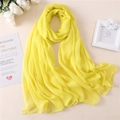 Dettaglio ravvicinato della sciarpa in chiffon giallo chiaro con pieghe morbide e fiori - Giallo