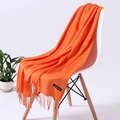 Vibrant orange cashmere scarf with tassel edges draped elegantly on a modern chair - Orange (FYR110-34)