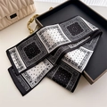 Detail of black and white paisley silk twilly scarf folded on a tray with handbag - Classic Black White Paisley (LJ21-H286)
