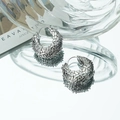 Gros plan de boucles d'oreilles créoles tressées en argent avec zircons étincelants - Argent(c306)