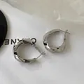 Detailansicht der silbernen gedrehten geometrischen Creolen mit poliertem Metall-Finish - Gedrehte Geometrische Ohrringe (D316) / Silber