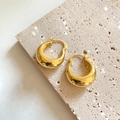 Dettagli di orecchini a cerchio dorati spessi su una superficie di pietra e pelle - Oro (C201)