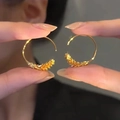 Macro shot of gold wheat ear hoop earrings with high-polish finish and embossed texture - Gold (Real Gold Plated) (E205)