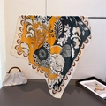 Artistieke zijdeachtige vierkante sjaal met bloemenprint hangend aan een metalen standaard - Geel