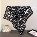 Carré de soie classique à pois noirs et blancs élégamment drapé avec un sac à main - Noir