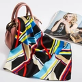 Silk satin square scarf with geometric color block design draped on a pink handbag - 50cm x 50cm / Black Geometric Patchwork