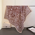 Detail of vintage paisley pattern on a brown silk scarf draped on a metal stand - Brown