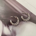Dettaglio di orecchini a cerchio intrecciati color argento con design a spirale - Argento (A201)