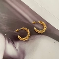 Dettaglio di orecchini a cerchio intrecciati placcati oro 18K su una rivista moda - Oro (A201)