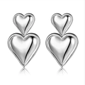 Macro shot of silver dual-heart earrings with high-polish finish and mirror reflection - Silver (A301)