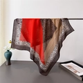 Detailed view of paisley patterns and soft silk-like texture on a square fashion scarf - 68*68cm / Orange Red