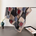 Dettaglio di un leggero foulard con motivi paisley e geometrici drappeggiato su un vaso - Beige