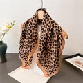 Classic leopard print lightweight scarf draped on a hanger over a white top for styling - Brown