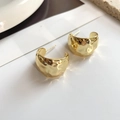 Dettaglio di spessi orecchini a C placcati in oro 18K con finitura in metallo martellato - Oro (E313)