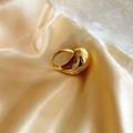 Macro-opname van 18K vergulde druppelring op een elegante satijnen achtergrond - Gouden druppelring