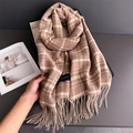 Close-up of soft plaid cashmere-feel scarf featuring elegant long tassels and woven label - Light Brown