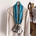 Teal silk scarf with crane pattern tied on a beige suit lapel with a wooden hanger - Lake Blue Crane Wave Pattern (LJ21-H277) / 145x12cm
