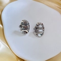 Detail of silver wavy irregular oval earrings on silk showing fluid reflective texture - Silver-B112