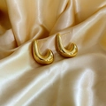 Vista macro di orecchini a forma di J placcati in oro 18K su elegante tessuto in seta champagne - Argento Grande (B317-4.5*3.0)