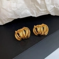 Makroaufnahme von mehrschichtigen, goldbeschichteten, gedrehten geometrischen Ohrringen - Gold